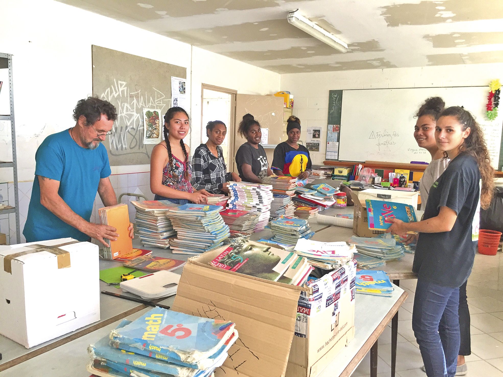 Un groupe d’étudiantes, à Nouville, aide les membres de l’association Ecoles Pikinini au rangement des cartons de fournitures scolaires à destination de Port-Vila.