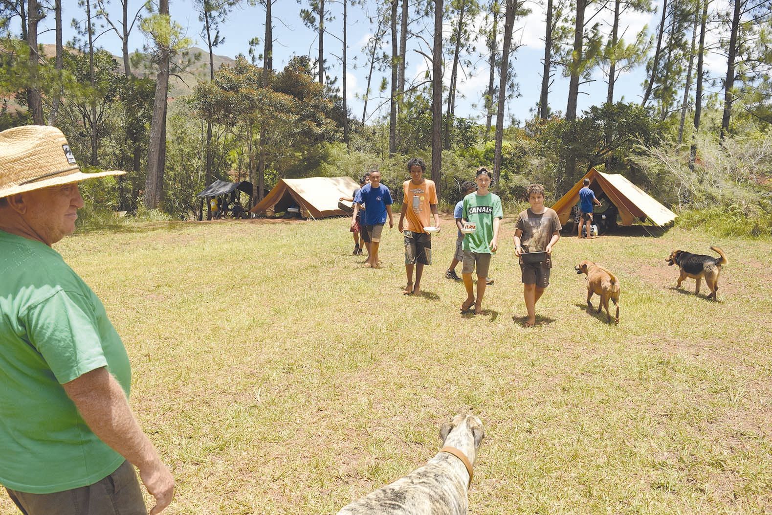 Michel Revercé, à gauche, est le président des Scouts laïcs de Nouvelle- Calédonie depuis les débuts de l’association. Il règne en maître sur son domaine, toujours accompagné de ses sept chiens.