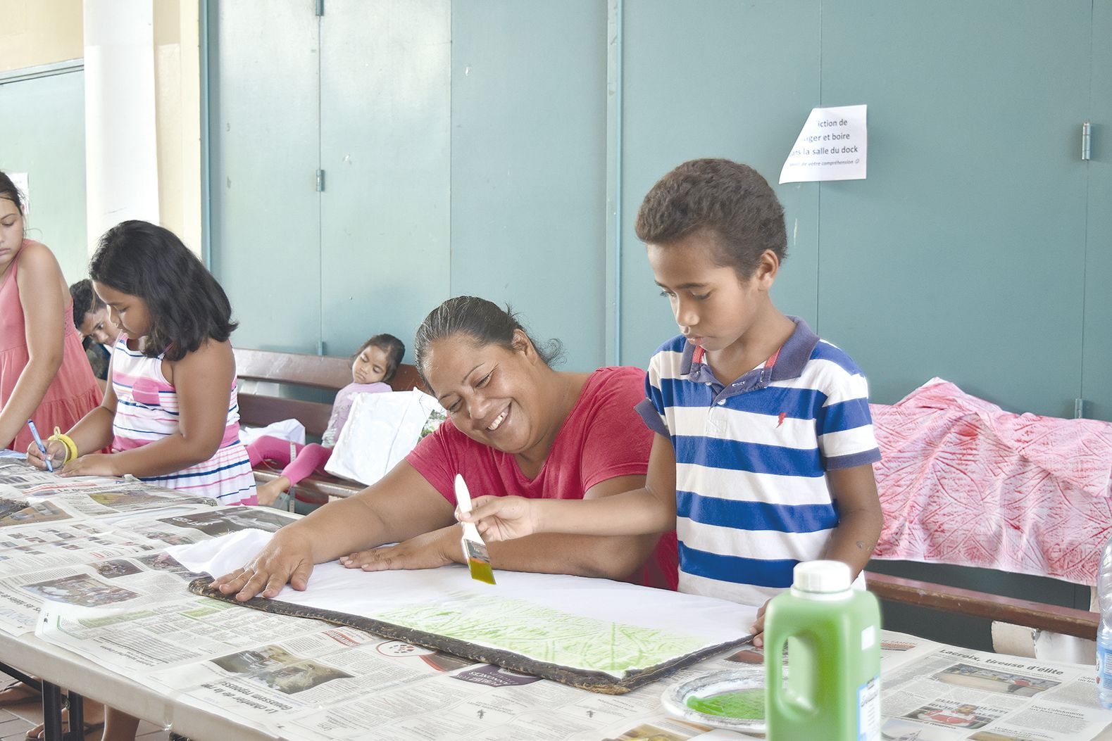 Manuel découvre la peinture sur tissu avec Ema Lakalaka. Cette méthode traditionnelle de Wallis-et-Futuna consiste à peindre un tissu placé sur un support appelé « kupesi », ce qui permet de faire apparaître des motifs sur le tissu.