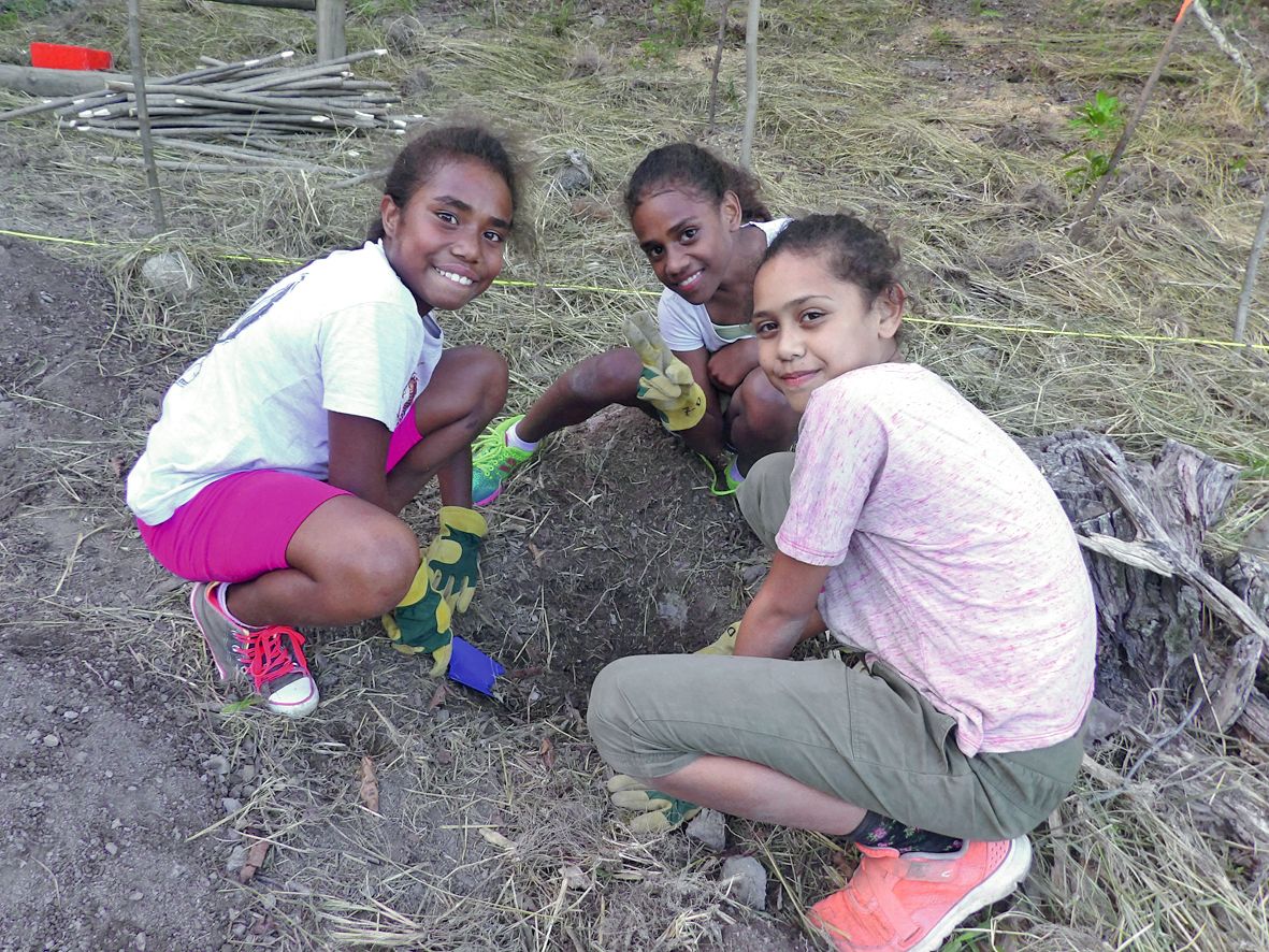 Les filles du rugby plantent des arbres, comme ici Glenda, à gauche, Saria et Cherlène, non sans fierté.