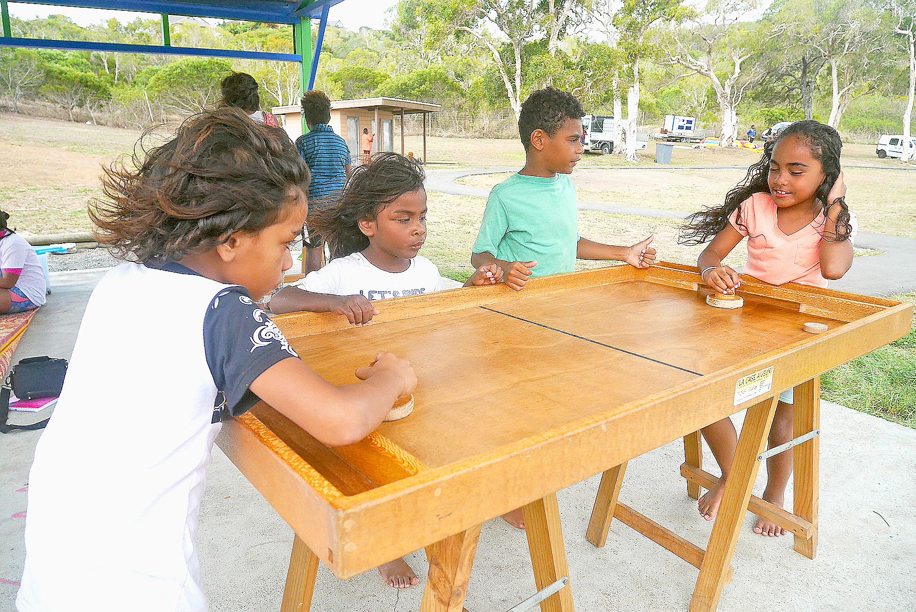 Au bord de la plage de Nouré, Aklieo et Laëticia, qui ont 6 et 8 ans, s’affrontent au jeu de la table à glisser. La ville de Dumbéa a aussi mis à disposition un Puissance quatre géant, des échecs et un double chinois. Un espace de lecture est également pr