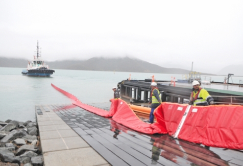 Vavouto, hier. L'une des premières étapes de la matinée : le déroulement du barrage par le remorqueur. Relié à un autre bateau, par son autre extrémité, il est tracté et vient encercler la nappe de tourbe déversée.