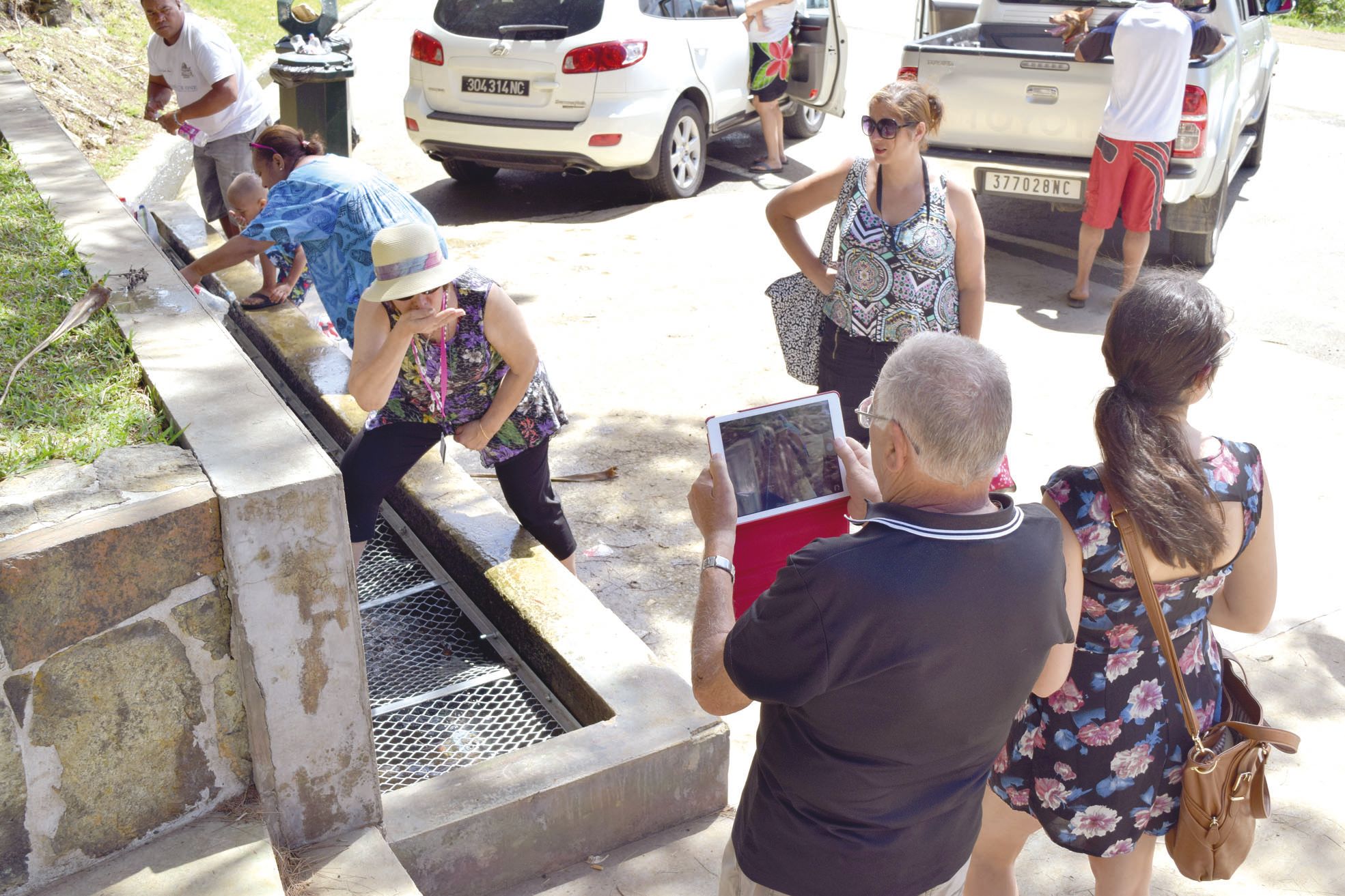 Fontaine de Plum, décembre 2015. Les touristes se prennent en photo en train de boire l'eau de la fontaine du Mont-Dore.