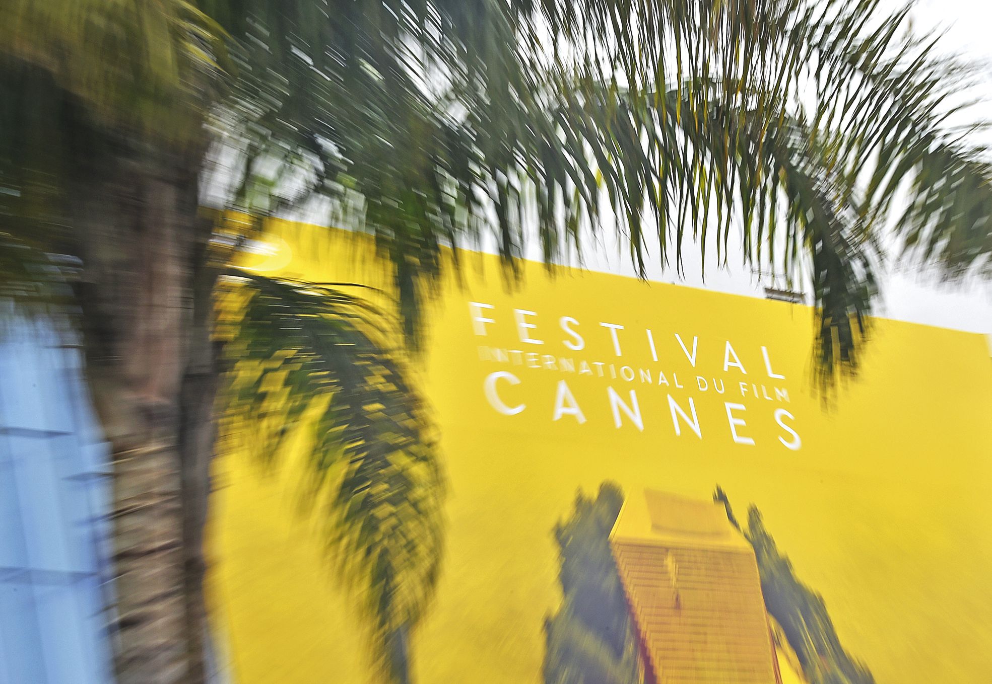 Cannes, le 9 mai. Des photographes attendent l'installation de la bannière officielle sur la façade du Palais des festivals.