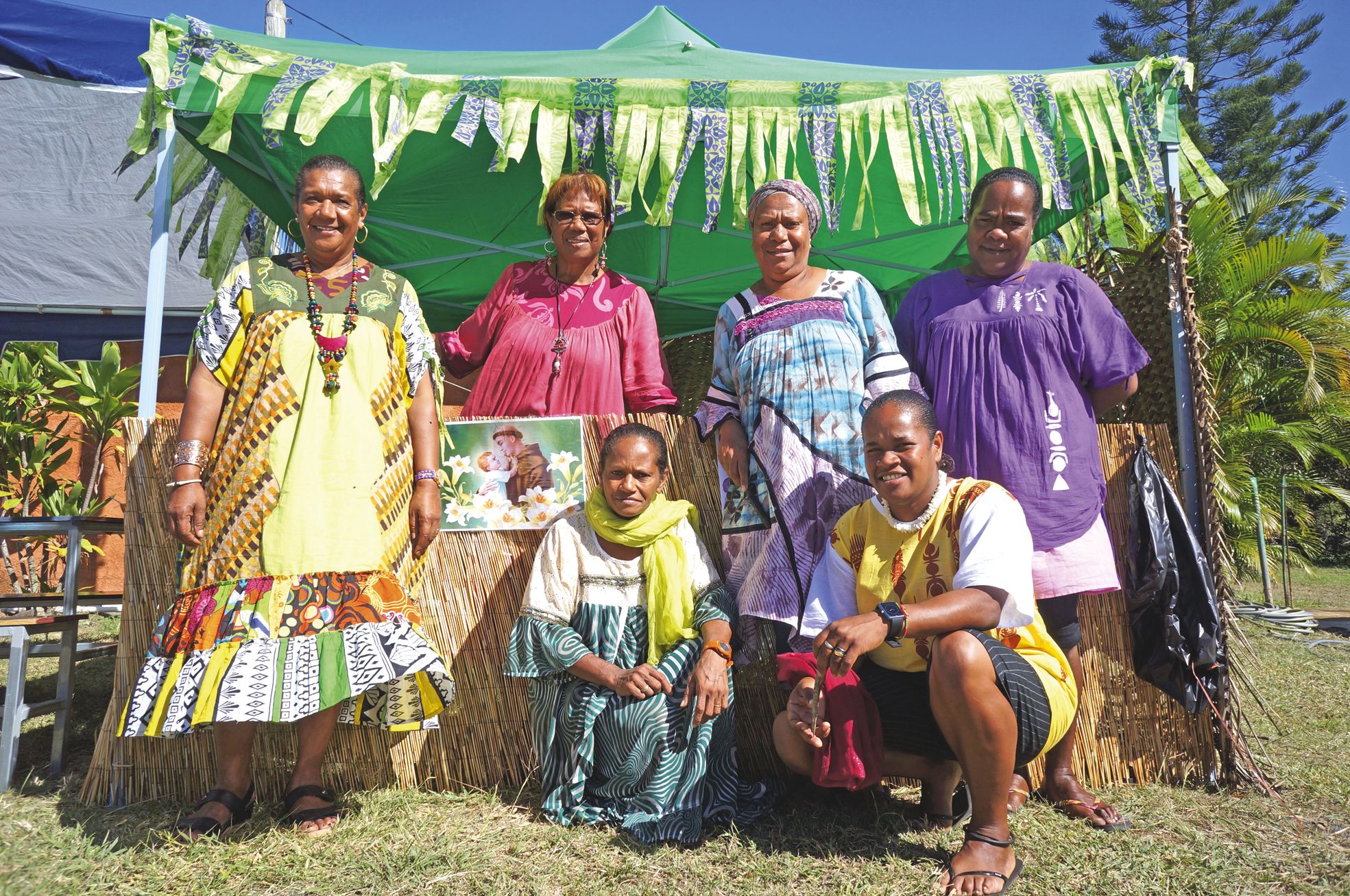 Samedi 18 juin, maison commune de N'Dé. Myriam, Marie-Luce, Graziella, Blandine, Mariza et Sylvie,  une partie des bénévoles, devant le stand de café et entourant une image de saint Antoine de Padoue.